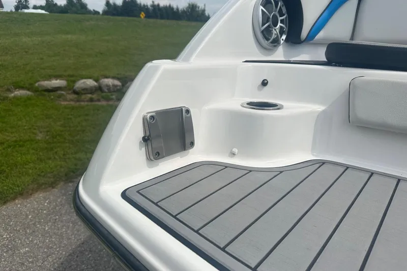 Slide: The Image of 2018 Yamaha 242 X boat deck with speaker and cup holder, set against a grassy background. - 9