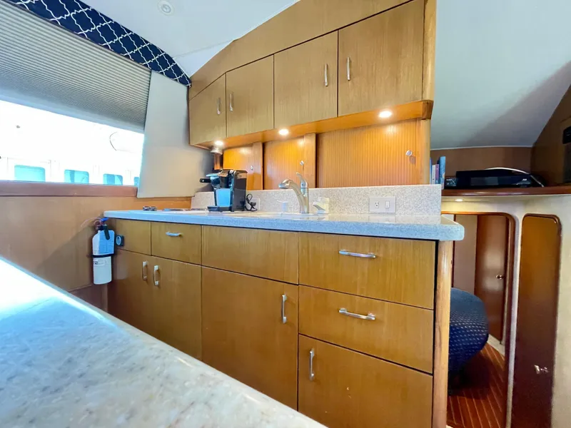 Slide: The Image of Interior of 2000 Ocean Yachts 43 Super Sport, featuring a modern kitchen with wood cabinetry. - 35