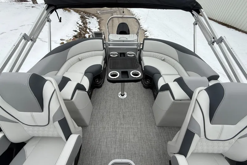 Slide: The Image of 2025 Tahoe 2185 boat interior with gray seating, cup holders, and a central table. - 10