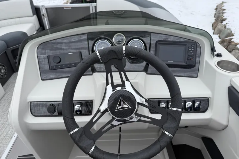 Slide: The Image of 2025 Tahoe 2185 boat dashboard with steering wheel, gauges, and navigation system. - 13