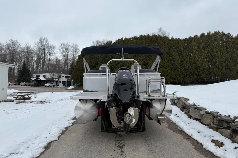 Slide: The Image of 2025 Tahoe 2185 pontoon boat with outboard motor on snowy driveway. - 4