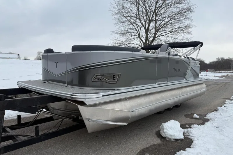 Slide: The Image of 2025 Tahoe 2185 pontoon boat on trailer, parked on snowy road. - 7