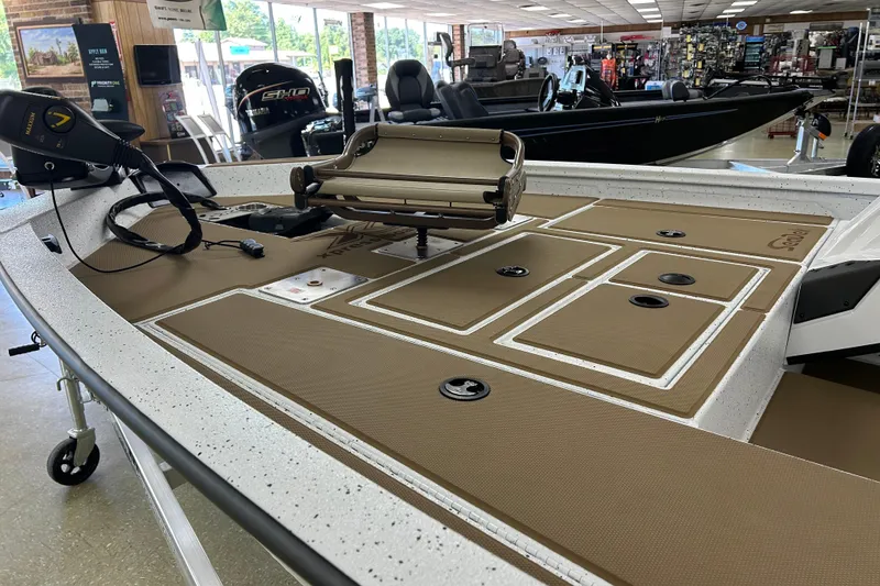 Slide: The Image of 2026 Xpress H18C Crappie boat interior with tan deck, showroom display. - 2