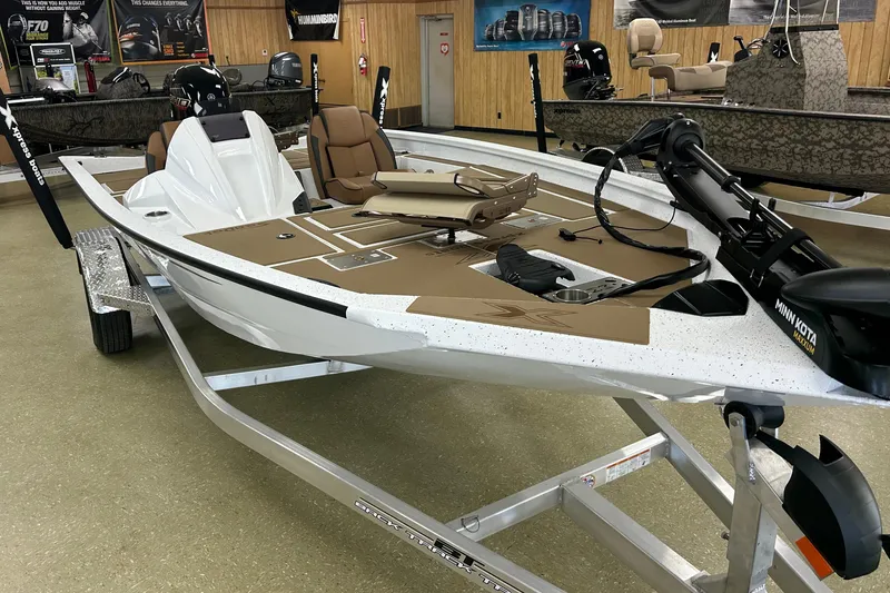 Slide: The Image of 2026 Xpress H18C Crappie boat in showroom, featuring Minn Kota trolling motor. - 6