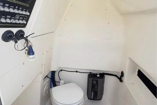 Slide: The Image of 2023 Boston Whaler 280 Vantage interior cabin with toilet and control panel. - 17