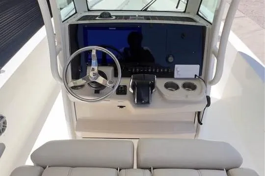 Slide: The Image of 2023 Boston Whaler 280 Vantage helm with steering wheel and control panel. - 19