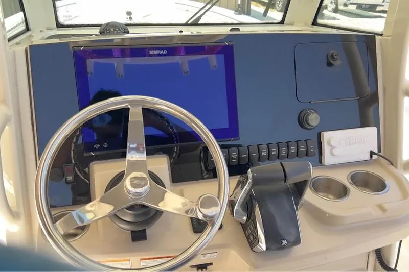 Slide: The Image of 2023 Boston Whaler 280 Vantage helm with steering wheel and navigation controls. - 20