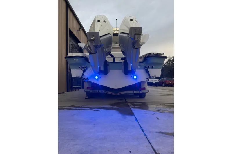 Slide: The Image of 2023 Boston Whaler 280 Dauntless boat with dual engines and blue lights in a storage area. - 25