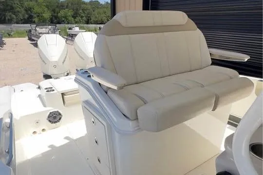 Slide: The Image of 2023 Boston Whaler 280 Vantage boat interior with cushioned seating and dual outboard motors. - 9