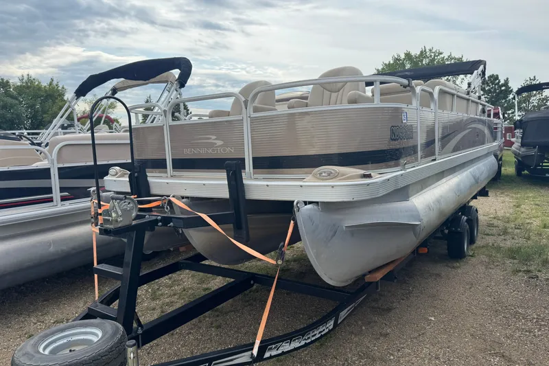 Slide: The Image of 2012 Bennington 24 SF pontoon boat on trailer, parked outdoors. - 1