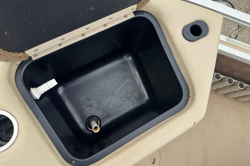 Slide: The Image of Open storage compartment on 2012 Bennington 24 SF boat, featuring a black interior. - 18