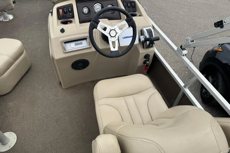 Slide: The Image of 2012 Bennington 24 SF boat interior with steering wheel and beige seating. - 21