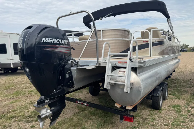Slide: The Image of 2012 Bennington 24 SF pontoon boat on trailer, parked outside a garage. - 3