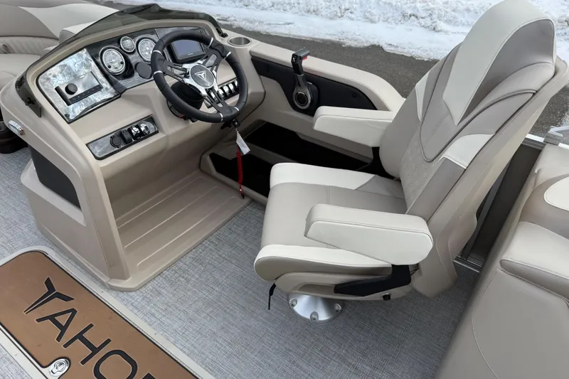 Slide: The Image of Captain's chair and dashboard of 2025 Tahoe 2185 boat, featuring modern controls and steering. - 12