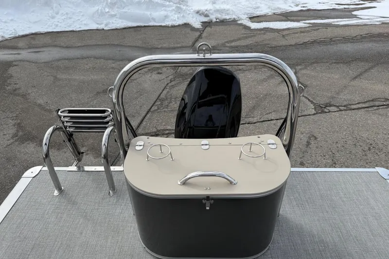 Slide: The Image of 2025 Tahoe 2185 boat stern with motor, ladder, and storage compartment on a snowy day. - 26