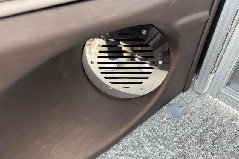 Slide: The Image of Speaker grille on a 2025 Tahoe 2185 boat, mounted on a brown panel. - 28