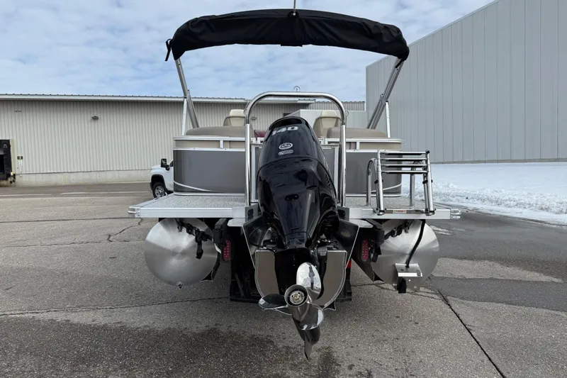 Slide: The Image of 2025 Tahoe 2185 pontoon boat with outboard motor, parked on concrete surface. - 4