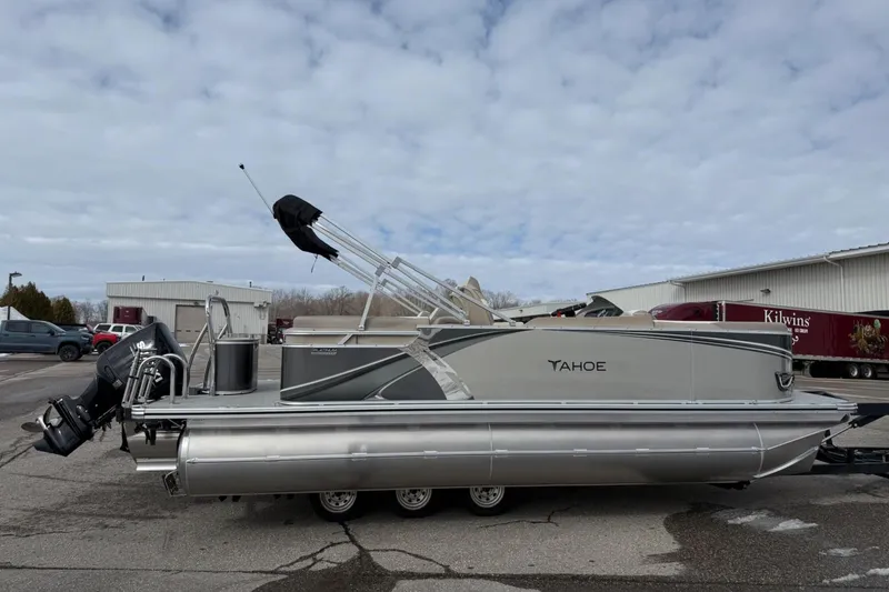 Slide: The Image of 2025 Tahoe 2185 pontoon boat parked outdoors under cloudy sky. - 6