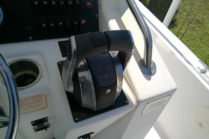 Slide: The Image of 2001 Boston Whaler 28 Outrage boat interior with white cushioned seating and steering wheel. - 25