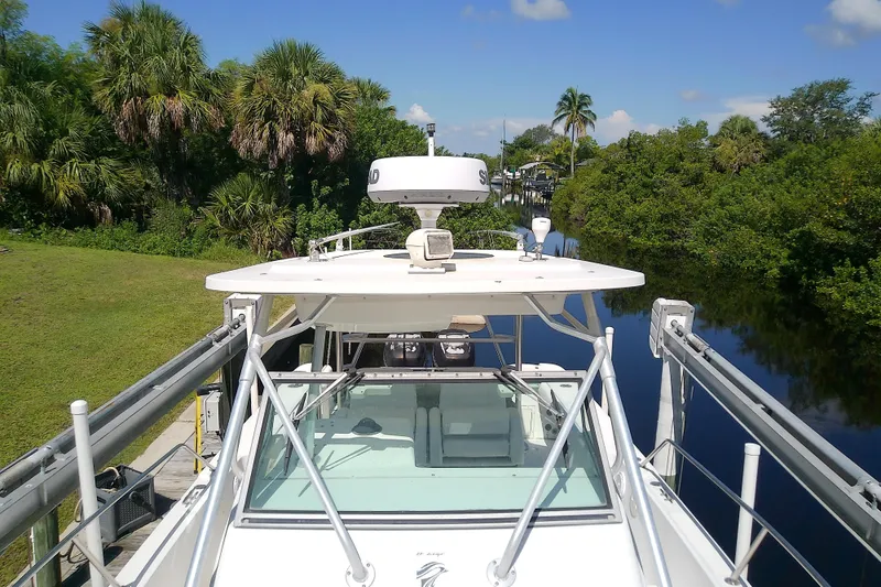 Slide: The Image of 2001 Boston Whaler 28 Outrage boat with seating, docked near waterfront. - 29