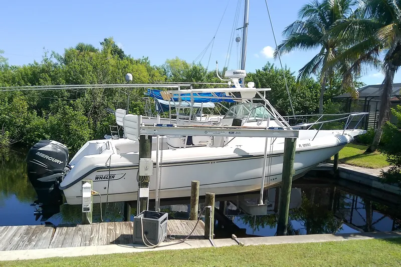 Slide: The Image of 2001 Boston Whaler 28 Outrage boat on trailer, parked outdoors under clear sky. - 3