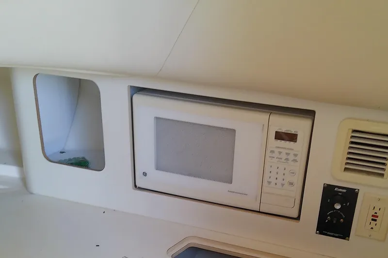 Slide: The Image of Interior cabin of 2001 Boston Whaler 28 Outrage with beige seating and wood flooring. - 36