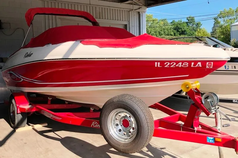 Slide: The Image of 2005 Rinker 192 Captiva BR boat with red cover and trailer in a garage. - 11