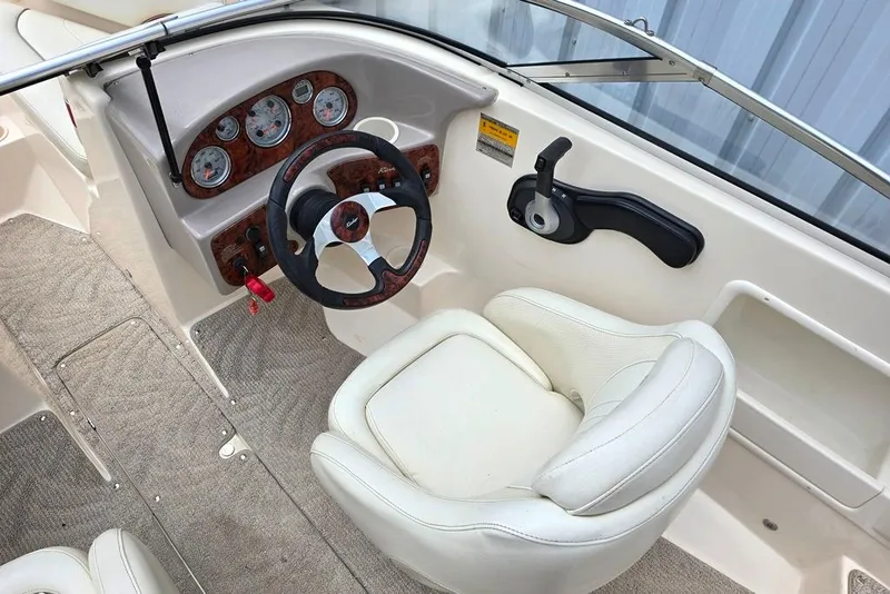 Slide: The Image of 2005 Rinker 192 Captiva BR boat interior with steering wheel and dashboard controls. - 2