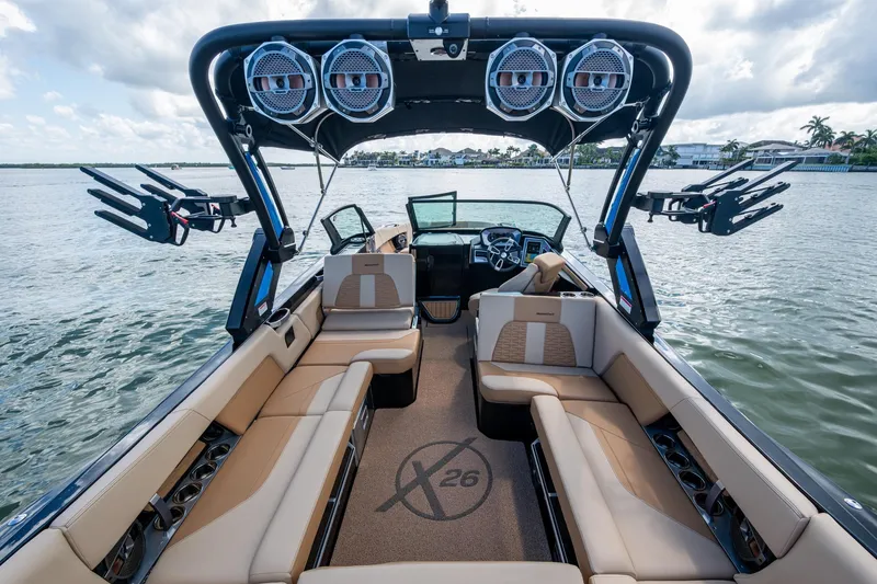 Slide: The Image of 2022 MasterCraft X26 boat interior with luxurious seating and advanced audio system on the water. - 11