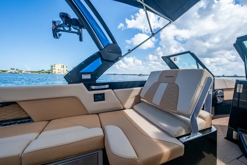 Slide: The Image of 2022 MasterCraft X26 boat interior with luxurious seating and scenic water view. - 15