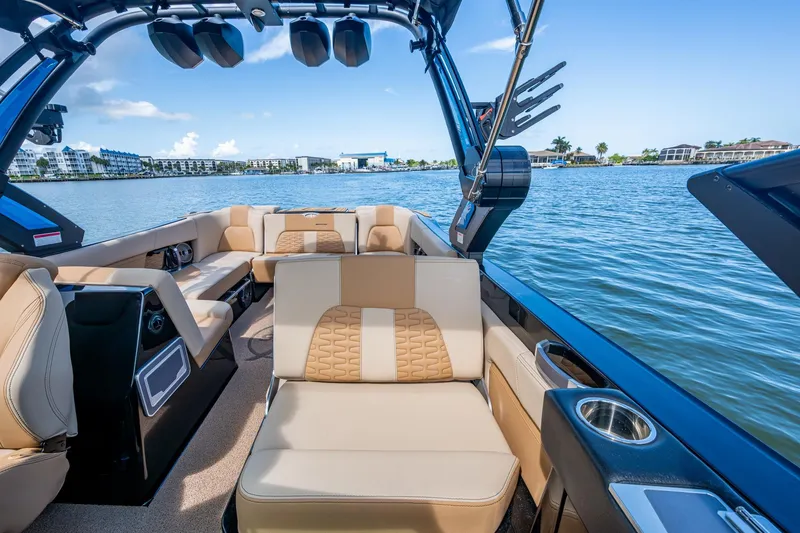 Slide: The Image of 2022 MasterCraft X26 boat interior with luxurious seating on a sunny day. - 16