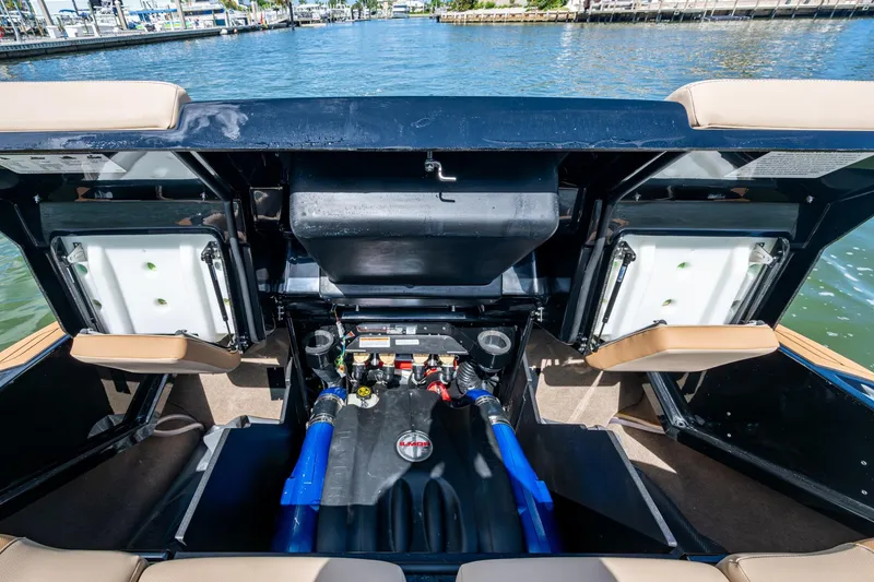 Slide: The Image of 2022 MasterCraft X26 boat engine compartment with open hatches, dockside view. - 23