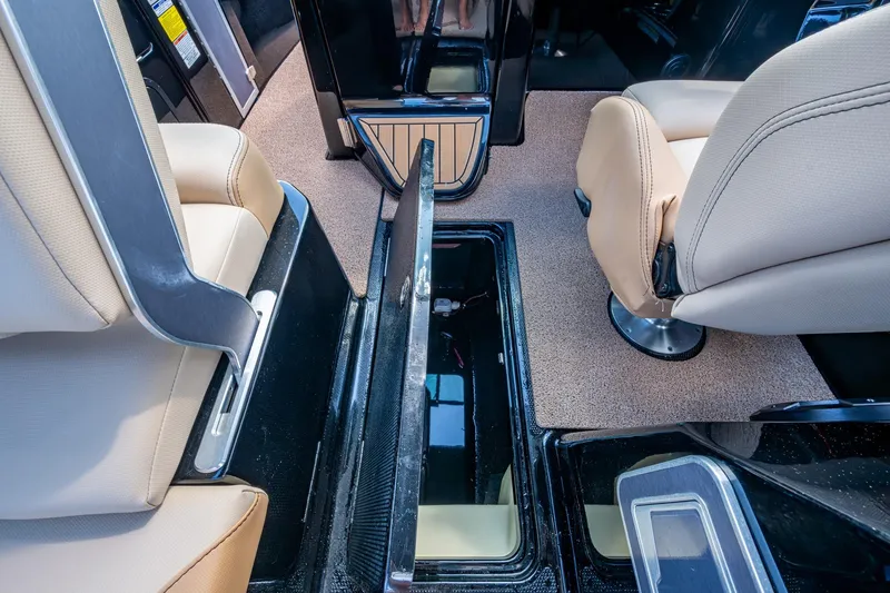 Slide: The Image of 2022 MasterCraft X26 interior with open storage compartment and beige seating. - 24
