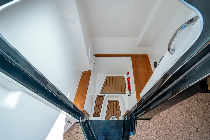 Slide: The Image of 2022 MasterCraft X26 boat interior with wooden flooring and fire extinguisher. - 25