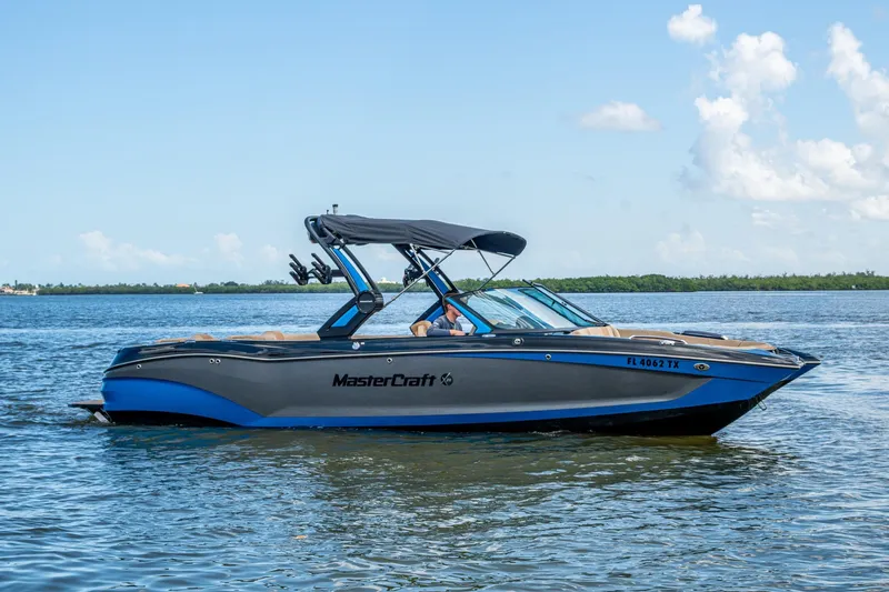 Slide: The Image of 2022 MasterCraft X26 boat on calm water, featuring sleek design and blue accents. - 3