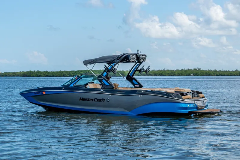 Slide: The Image of 2022 MasterCraft X26 boat on calm water under a clear sky. - 7