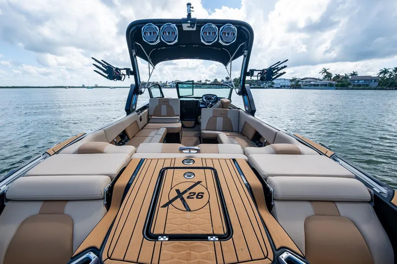 Slide: The Image of 2022 MasterCraft X26 luxury boat interior with spacious seating on a calm lake. - 9
