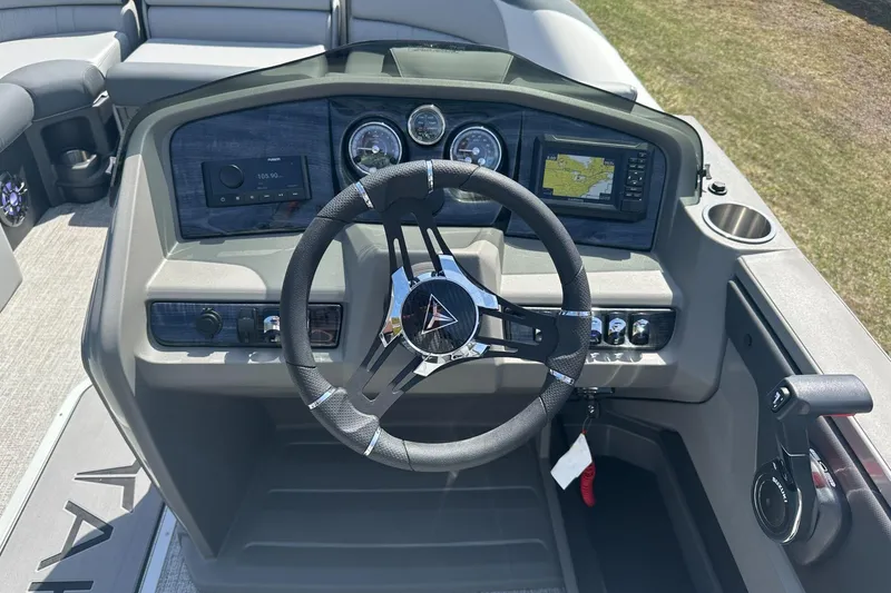 Slide: The Image of 2025 Tahoe 2185 boat dashboard with steering wheel, gauges, and navigation system. - 18