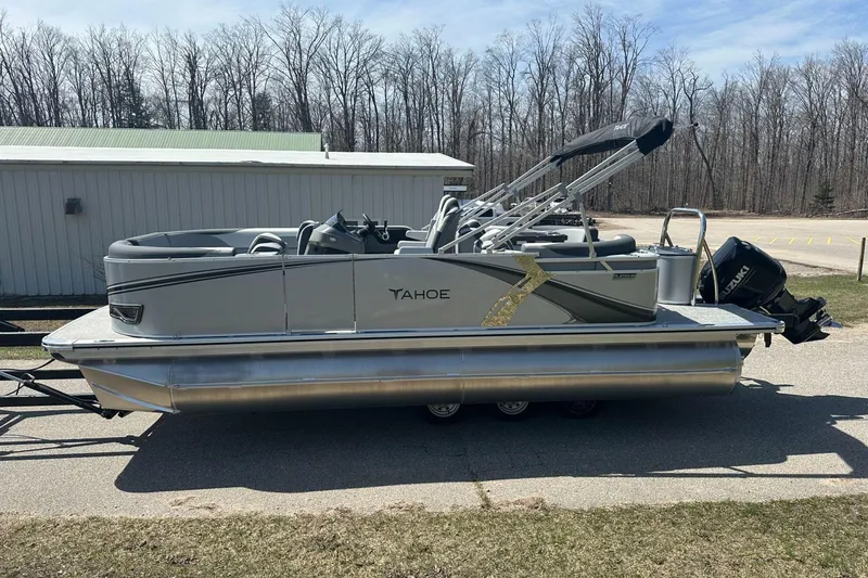 Slide: The Image of 2025 Tahoe 2185 pontoon boat with Suzuki outboard motor, parked outdoors. - 5