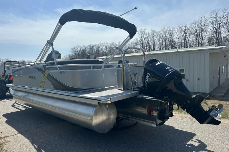 Slide: The Image of 2025 Tahoe 2185 pontoon boat with Suzuki outboard motor, parked outdoors. - 6
