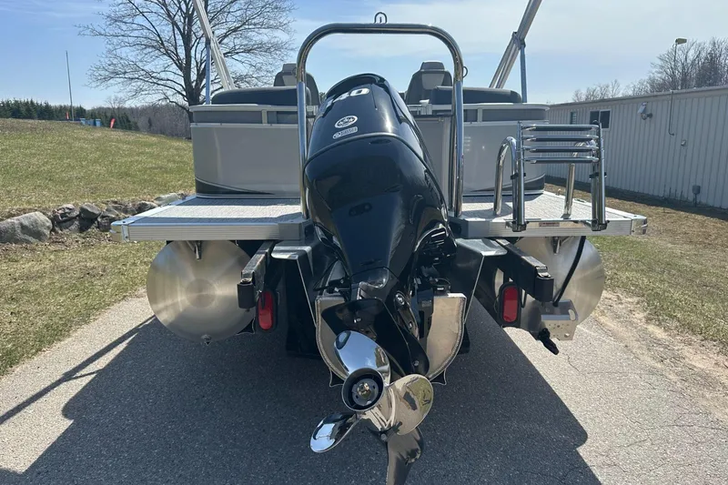 Slide: The Image of 2025 Tahoe 2185 pontoon boat with outboard motor, parked on a sunny day. - 7
