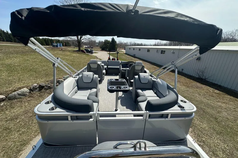 Slide: The Image of 2025 Tahoe 2185 pontoon boat with canopy, gray seating, and cup holders on a sunny day. - 9
