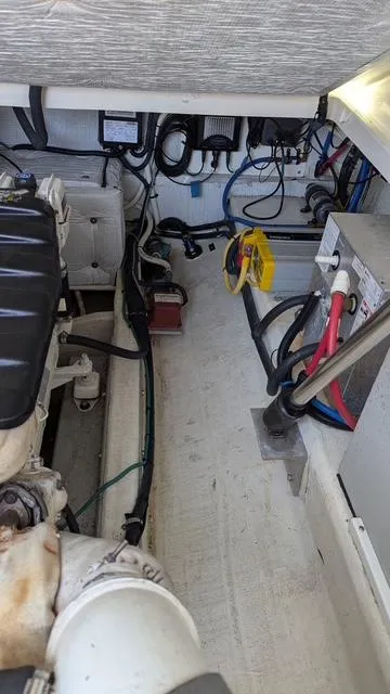 Slide: The Image of Engine compartment of a 2011 Back Cove 30 boat, showcasing wiring and mechanical components. - 14