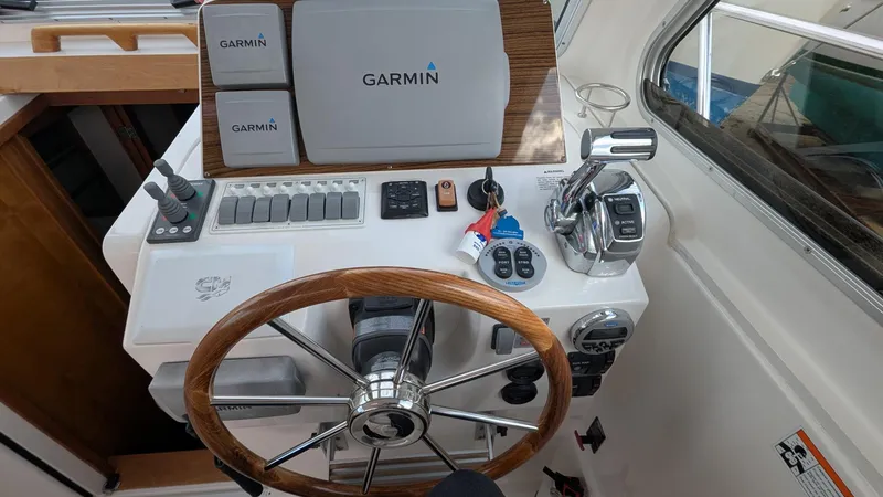 Slide: The Image of Helm of 2011 Back Cove 30 boat with Garmin navigation system and wooden steering wheel. - 6