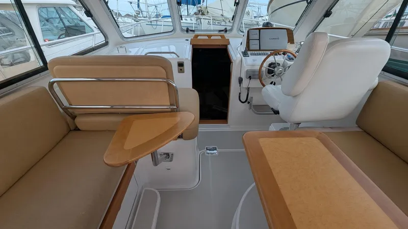 Slide: The Image of Interior of 2011 Back Cove 30 boat with beige seating and modern helm. - 7