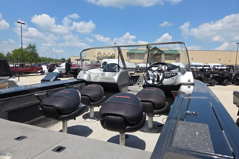 Slide: The Image of 2012 Tracker Targa V-18 boat with seating, parked outside Cabela's under a blue sky. - 3