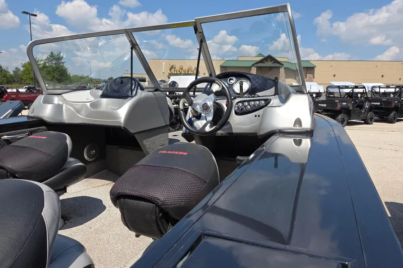 Slide: The Image of 2012 Tracker Targa V-18 boat interior with steering wheel and dashboard, parked outdoors. - 4