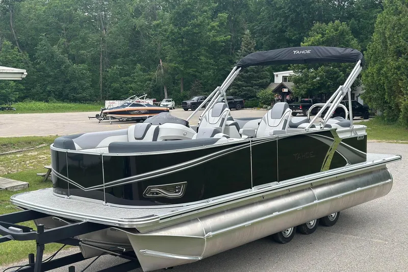 Slide: The Image of 2025 Tahoe 2185 pontoon boat with sleek design, parked outdoors. - 1