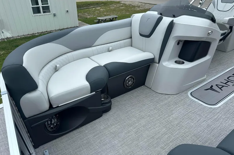 Slide: The Image of 2025 Tahoe 2185 boat interior with gray and white seating, cup holder, and speaker. - 13