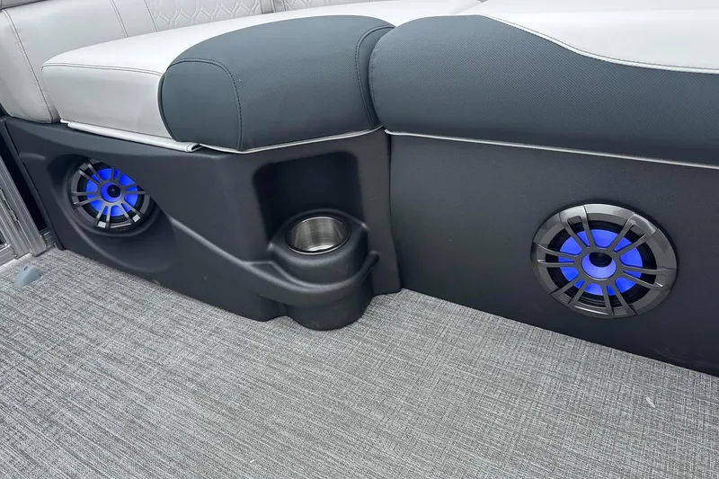 Slide: The Image of 2025 Tahoe 2185 interior with blue LED speakers and cup holder on gray carpet. - 14